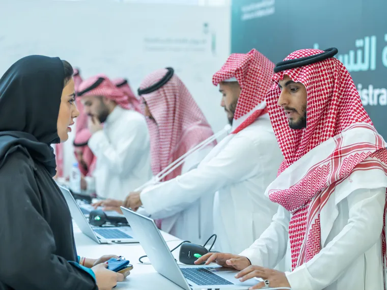 موظفون سعوديون يقدمون خدمة رقمية في مكتب حكومي