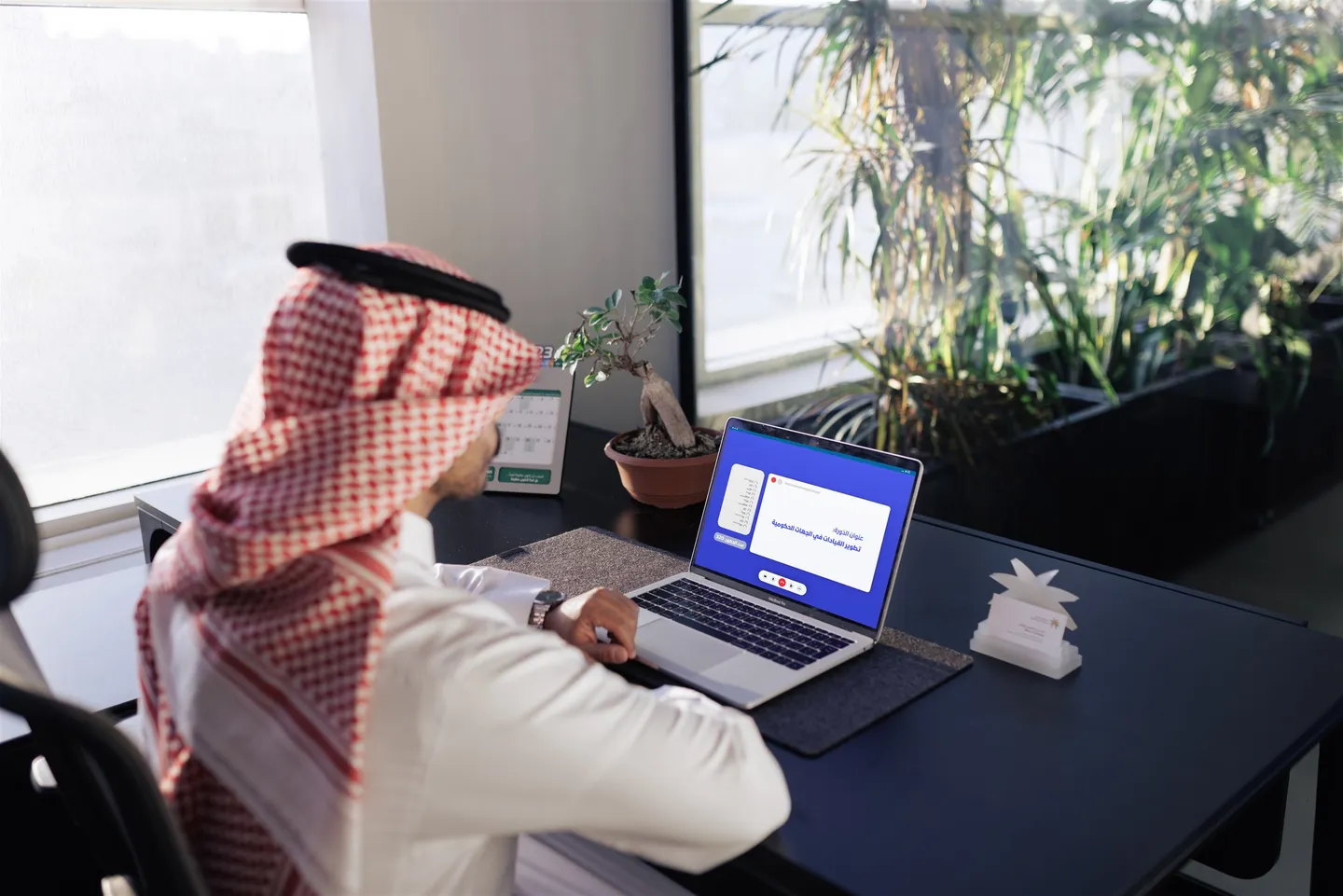 موظف سعودي ينجز معاملات رقمية عبر الحاسب المحمول
