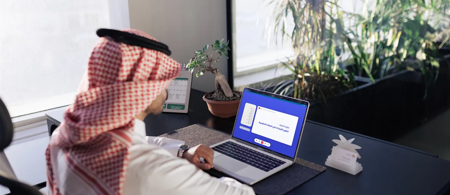 موظف سعودي ينجز معاملات رقمية عبر الحاسب المحمول