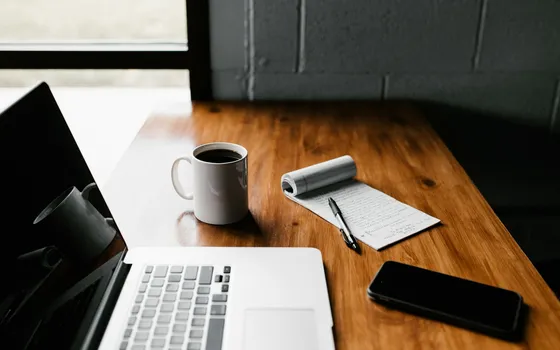 مساحة عمل تضم حاسوبًا وملاحظات مكتوبة لتجهيز المستندات