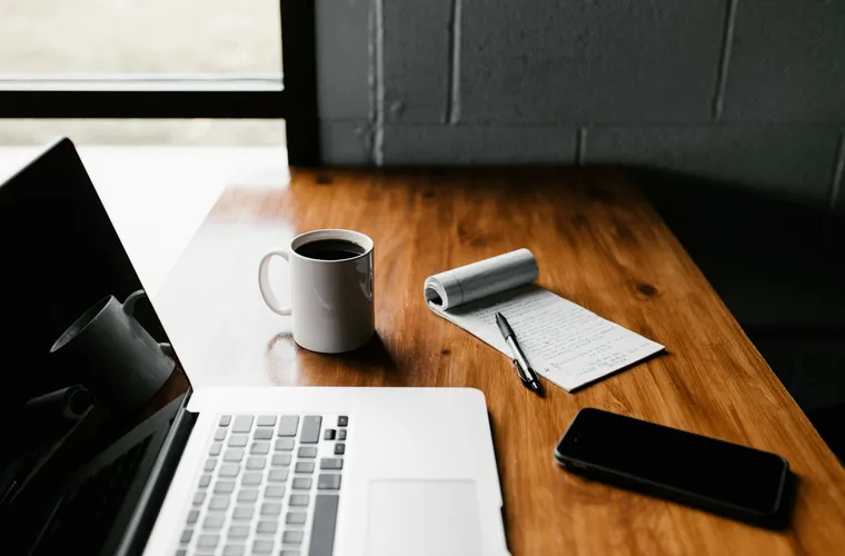 مساحة عمل تضم حاسوبًا وملاحظات مكتوبة لتجهيز المستندات