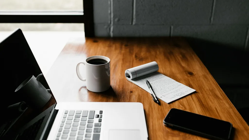 مساحة عمل تضم حاسوبًا وملاحظات مكتوبة لتجهيز المستندات